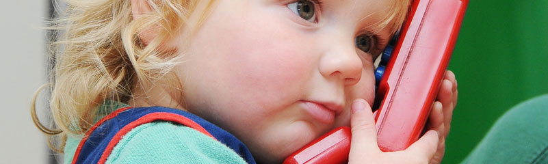 child holds play phone to ear