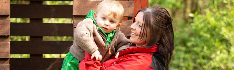 staff member holding child outdoors